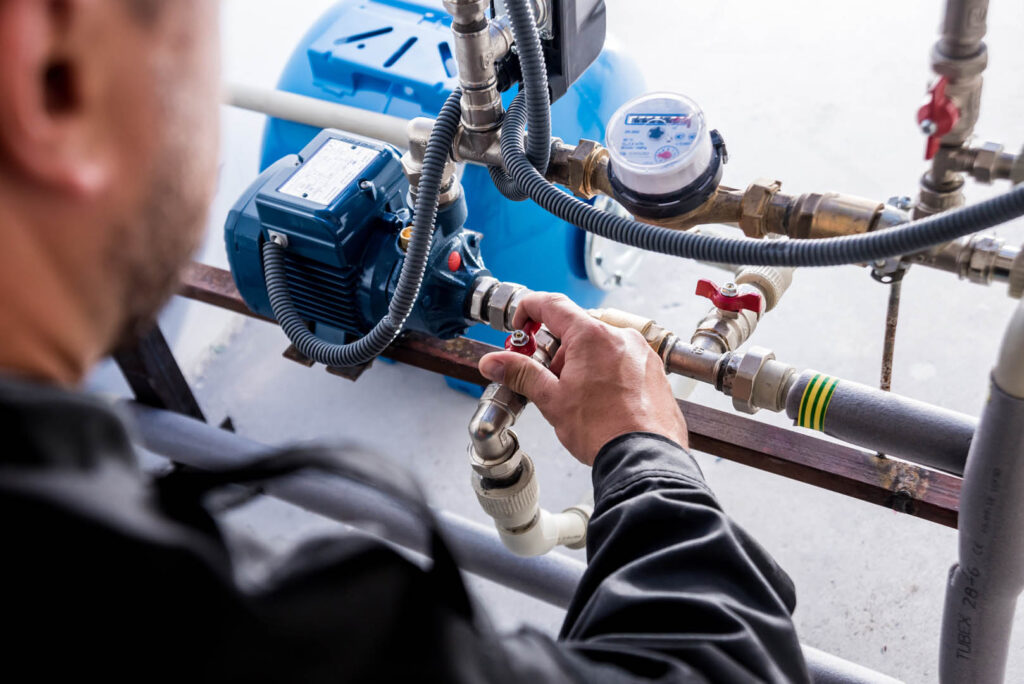 Technician checking water system nodes. Industrial background